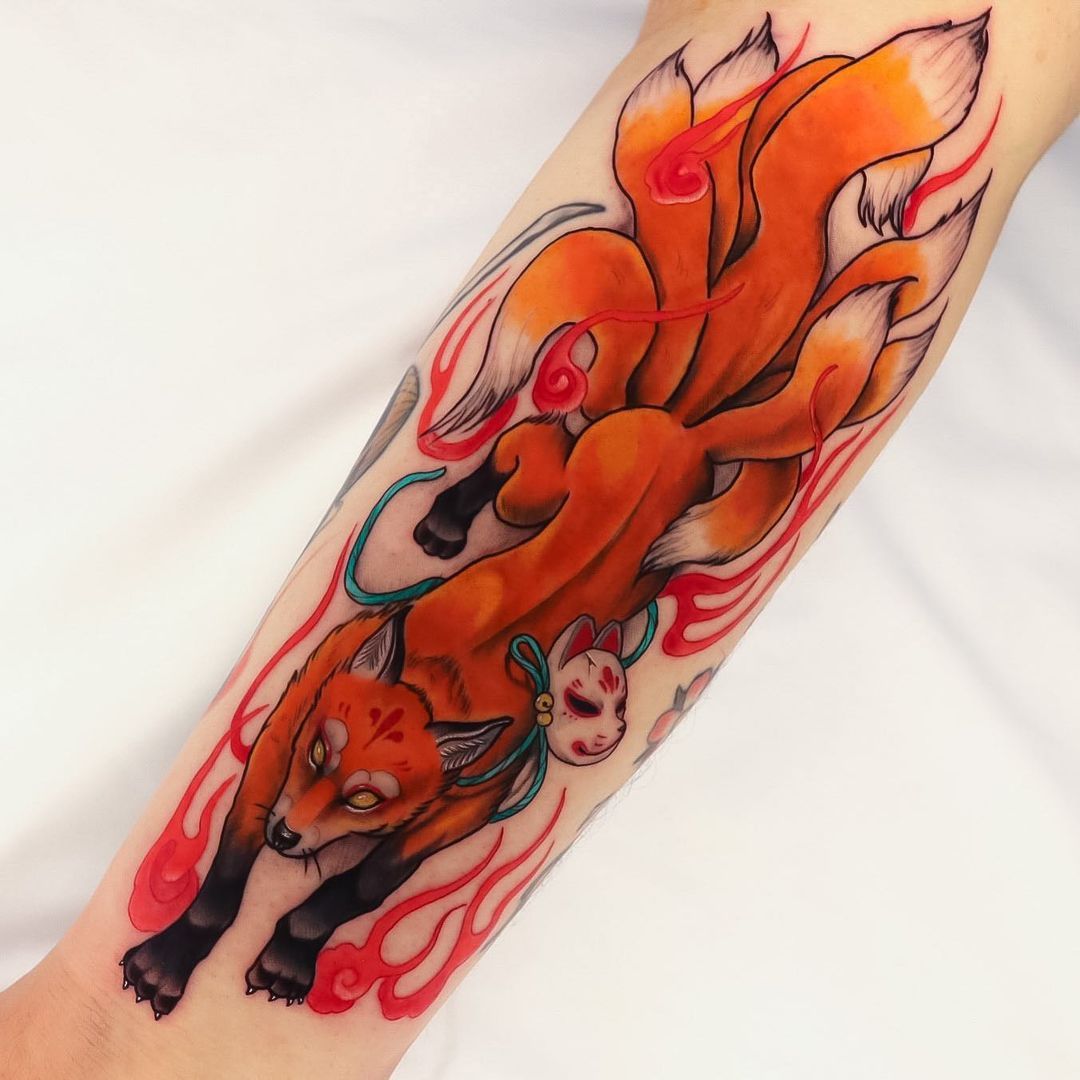 Colorful tattoo of a fox and a cat on a person's arm