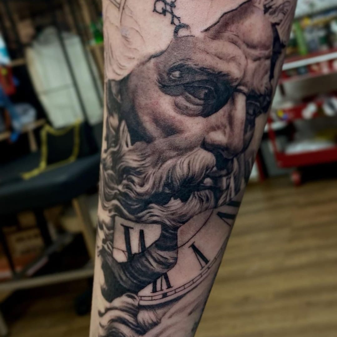 Black and grey tattoo of a classical figure with a clock on an arm