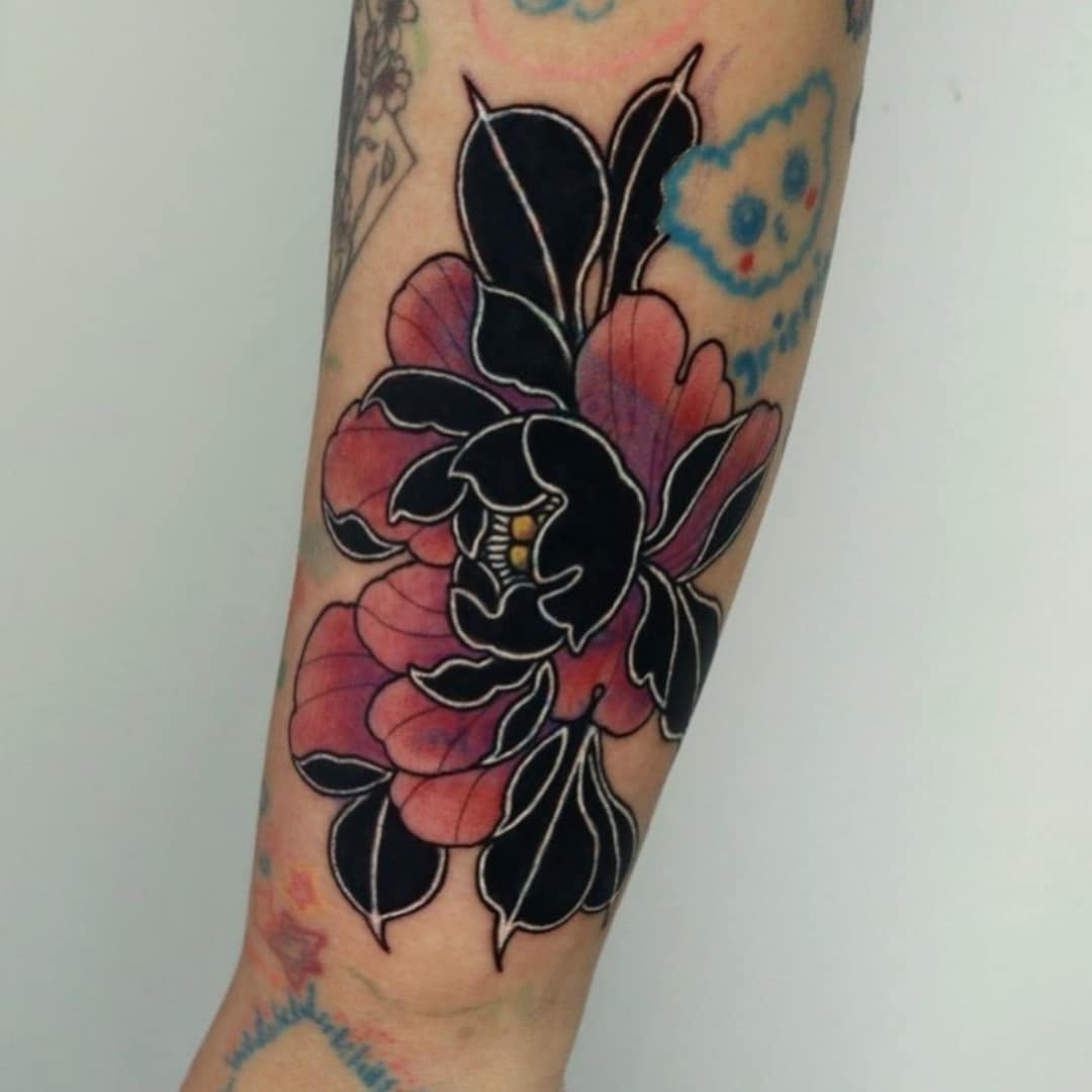 Tattoo of a black and pink flower on an arm