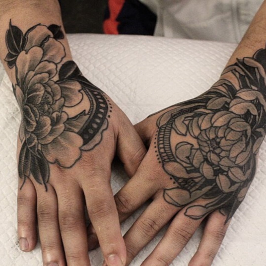 Black and grey floral tattoos on hands
