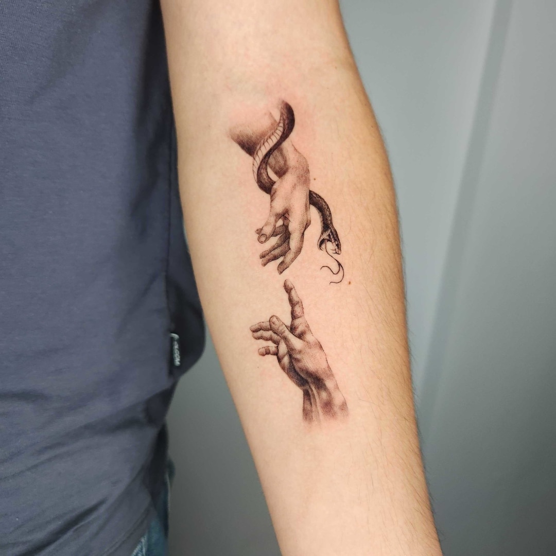 Tattoo of hands and snake on forearm