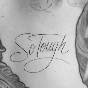 Stylized tattoo reading 'So Tough' on skin.