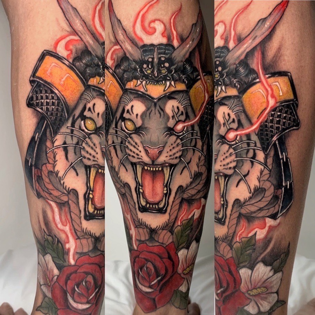 Vivid tattoo of a roaring tiger with samurai armor and flowers