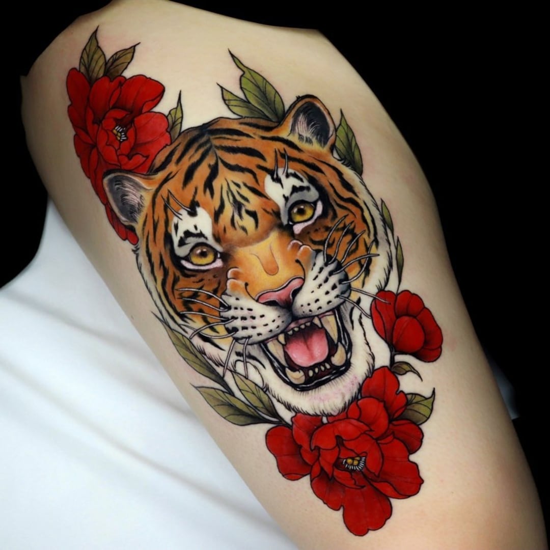 Colorful tattoo of a tiger surrounded by red flowers